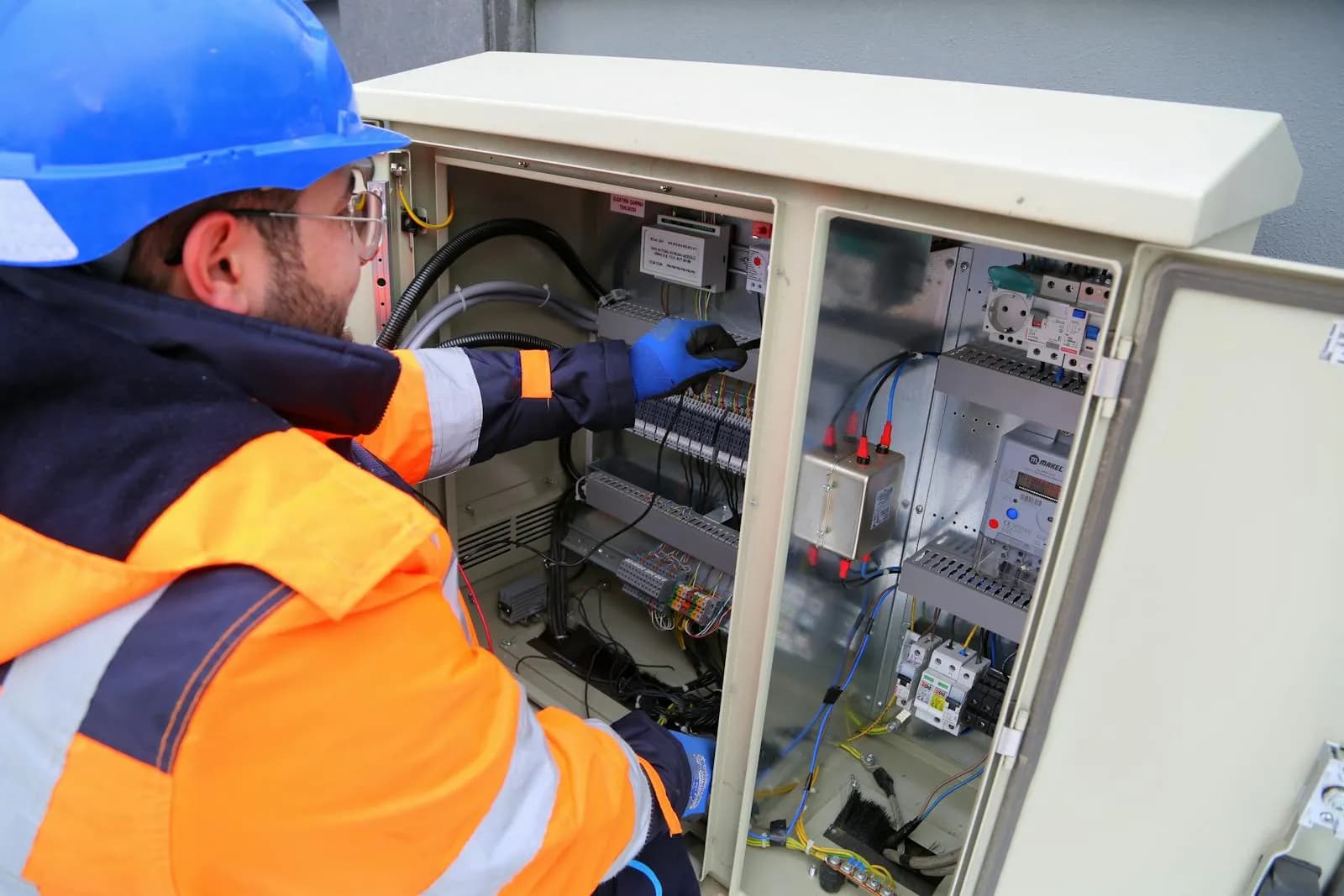 Technicien en EPI inspectant une armoire électrique