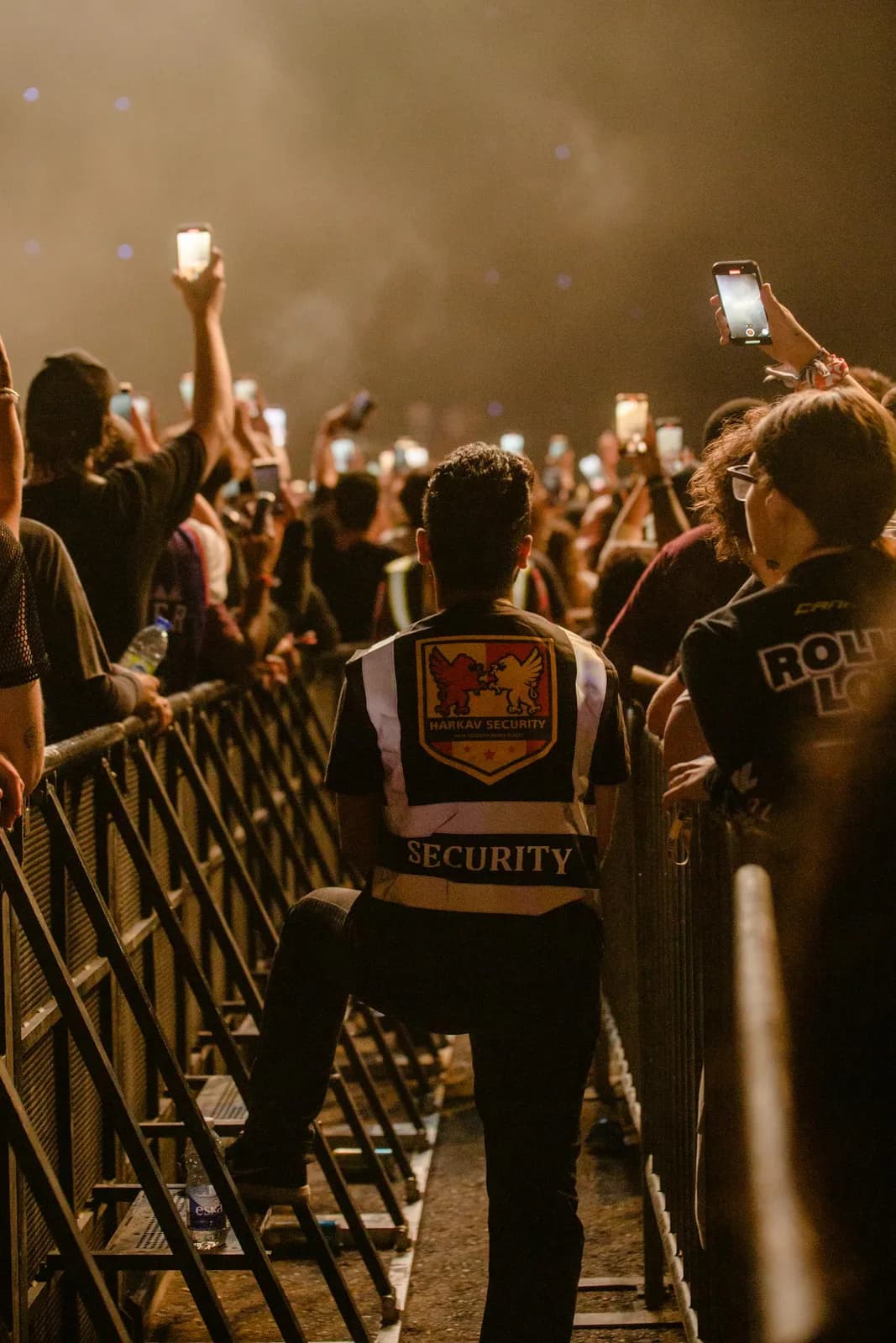 Agent de sécurité contrôlant une foule lors d'un concert nocturne